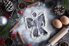 an angel cookie surrounded by christmas decorations and baking utensils