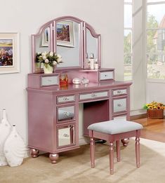 a pink vanity desk with mirror and stool