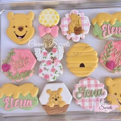 a box filled with lots of decorated cookies in the shape of winnie the pooh