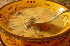 a yellow bowl filled with soup on top of a table