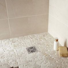 a white tiled bathroom with a toilet and shower head