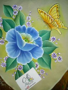 a painted plate with blue flowers and butterflies on it