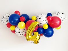 balloons are arranged in the shape of a number and a golden balloon with paw prints