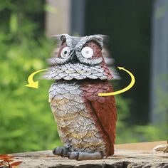 an owl figurine sitting on top of a piece of wood with the eyes open