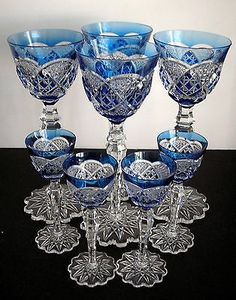 six blue glass goblets on a black table