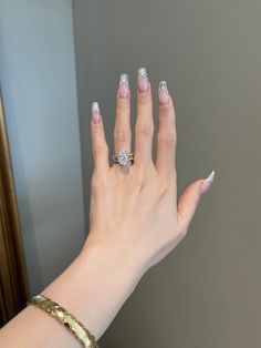 a woman's hand with white manicures and a ring on her finger