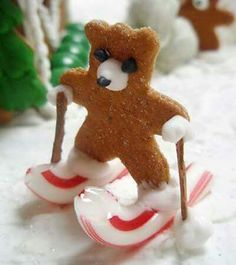 a gingerbread teddy bear sitting on top of a candy cane