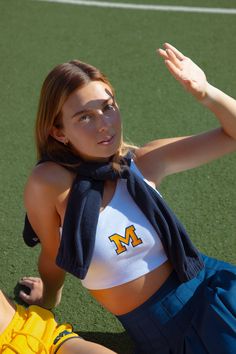 a woman sitting on top of a tennis court holding a racquet in her hand