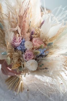 a bridal bouquet with feathers and flowers