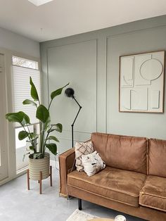 a living room filled with furniture and a potted plant