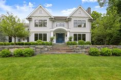 a large white house sitting on top of a lush green field