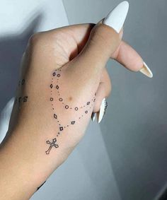 a woman's hand with a cross tattoo on it