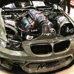 the engine compartment of a silver car on display