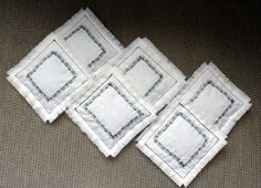 four white napkins sitting on top of a brown cloth covered floor next to each other