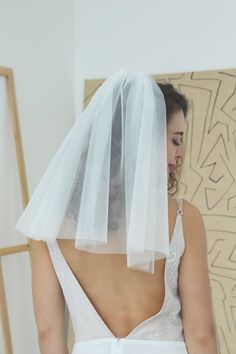 the back of a bride's wedding dress, with her veil draped over her head