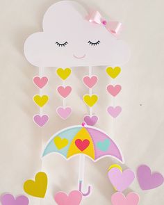 a paper umbrella with hearts hanging from it's side and a cloud above it