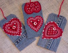 three pieces of fabric with hearts on them hanging from red string and two pairs of blue jeans