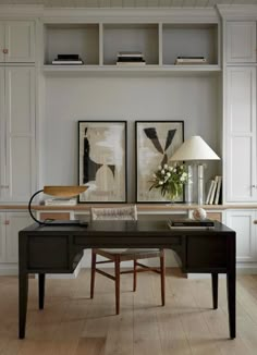 a home office with two framed pictures on the wall