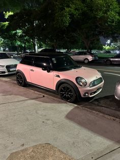 two cars parked next to each other on the side of a road at night time