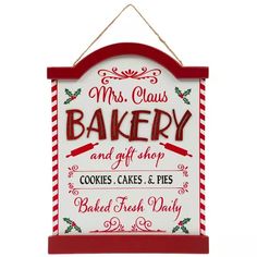 a red and white sign that says mrs claus's bakery and gift shop cookies, cakes & pies baked fresh daily