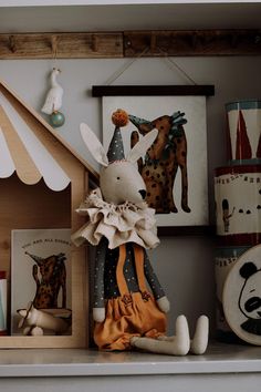 a stuffed animal is sitting on a shelf in front of pictures and other items,