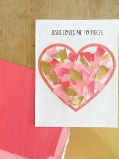 a heart shaped piece of paper on top of pink and yellow papers with the words jesus loves me to pieces