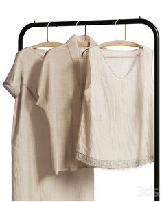 two white shirts hanging on clothes racks next to each other