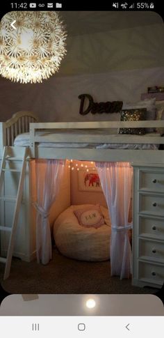 a white bunk bed with curtains and lights on the bottom, next to a dresser