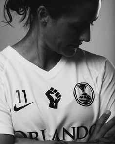 black and white photograph of a female soccer player with her hands clasped in front of her chest