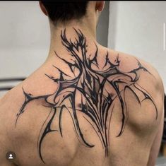 the back of a man's neck is covered in black ink with an abstract tree design