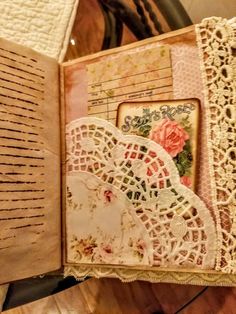 an open book with lace and flowers on it