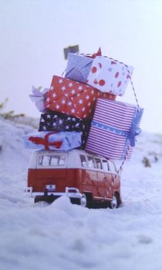 an old vw van is loaded with presents on the snow covered mountain side for christmas