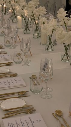 the table is set with place settings and goldware for guests to sit down at