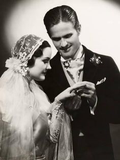 black and white photograph of a bride and groom looking at something on their cell phone