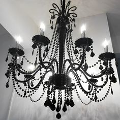 a chandelier hanging from the ceiling in a room with white walls and lights