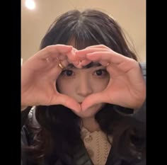 a woman making a heart with her hands