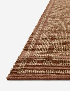 a brown and beige area rug on a white background