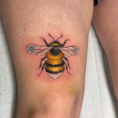 a small bee tattoo on the leg