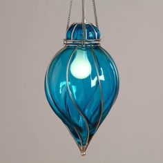 a blue glass ornament hanging from a chain