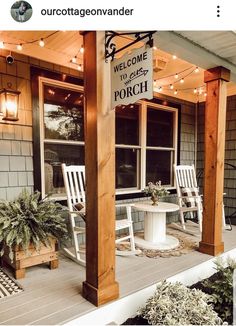 a porch with chairs and a table on the front porch is lit up by string lights