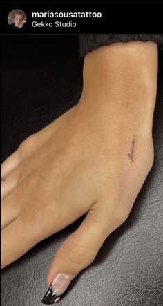 a woman's hand with a small tattoo on it