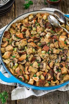 a blue casserole dish filled with stuffing and vegetables