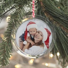 a christmas ornament hanging from a tree with a photo on it and a candy cane