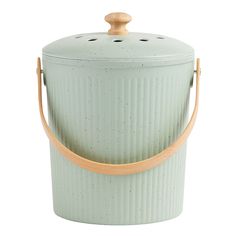 a green ceramic container with wooden handles