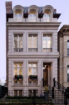 an apartment building with many windows and balconies on the second floor, along with wrought iron railings