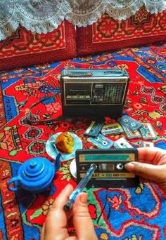 a person holding an old radio on top of a rug