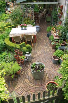 an outdoor garden with potted plants and tables