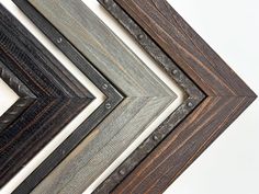 four different frames are shown together on the wall, one is made out of wood and the other has metal rivets