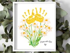 a watercolor painting of yellow flowers with hand prints