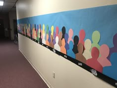 an office hallway decorated with colorful paper cutouts on the wall and carpeted floor